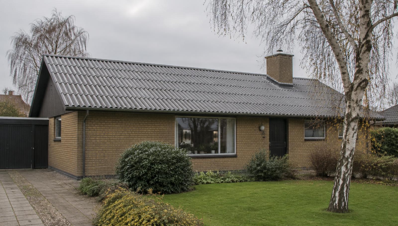 Dansk parcelhus med gråt bølgeeternittag og gul murstensfacade